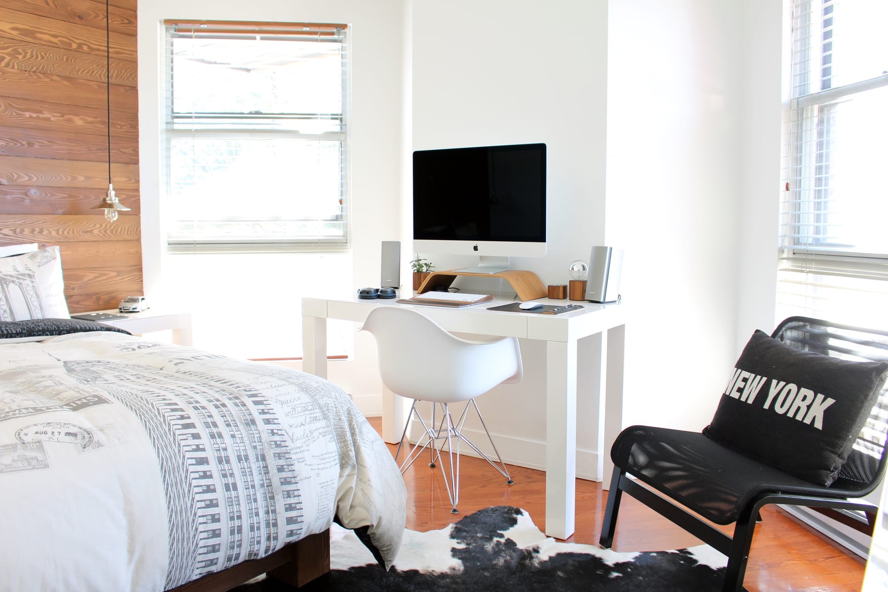 Chambre de loft new-yorkais, poutrelles métalliques apparentes et grande fenêtre.
