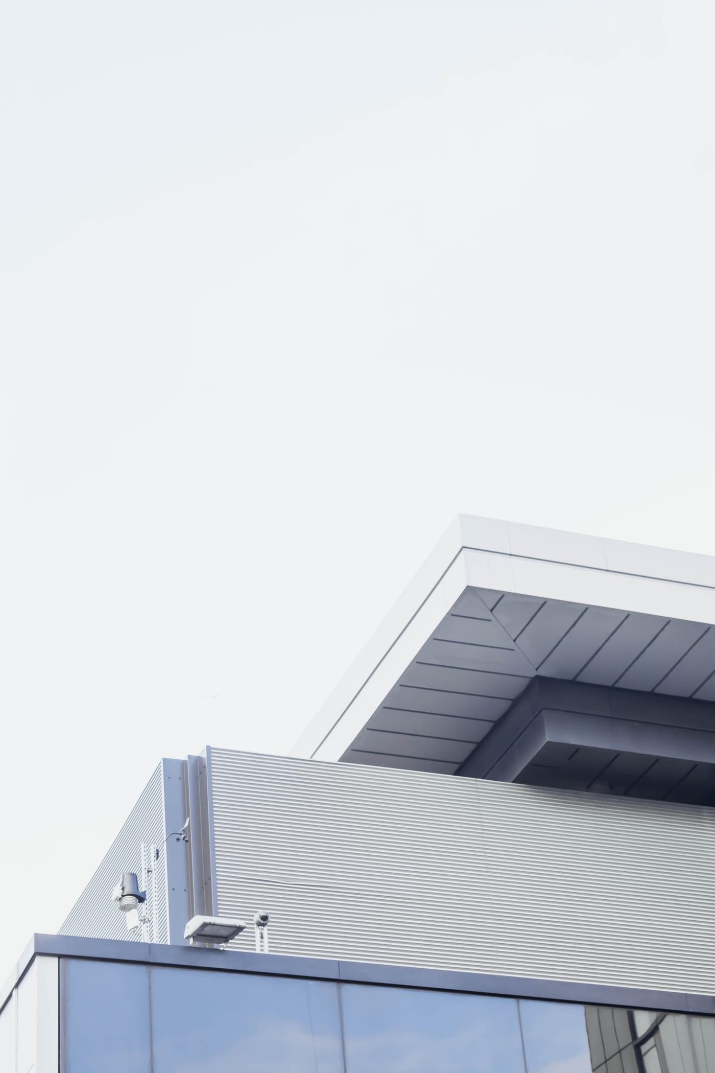Détail vertical d'une façade contemporaine blanche aux lignes géométriques nettes.